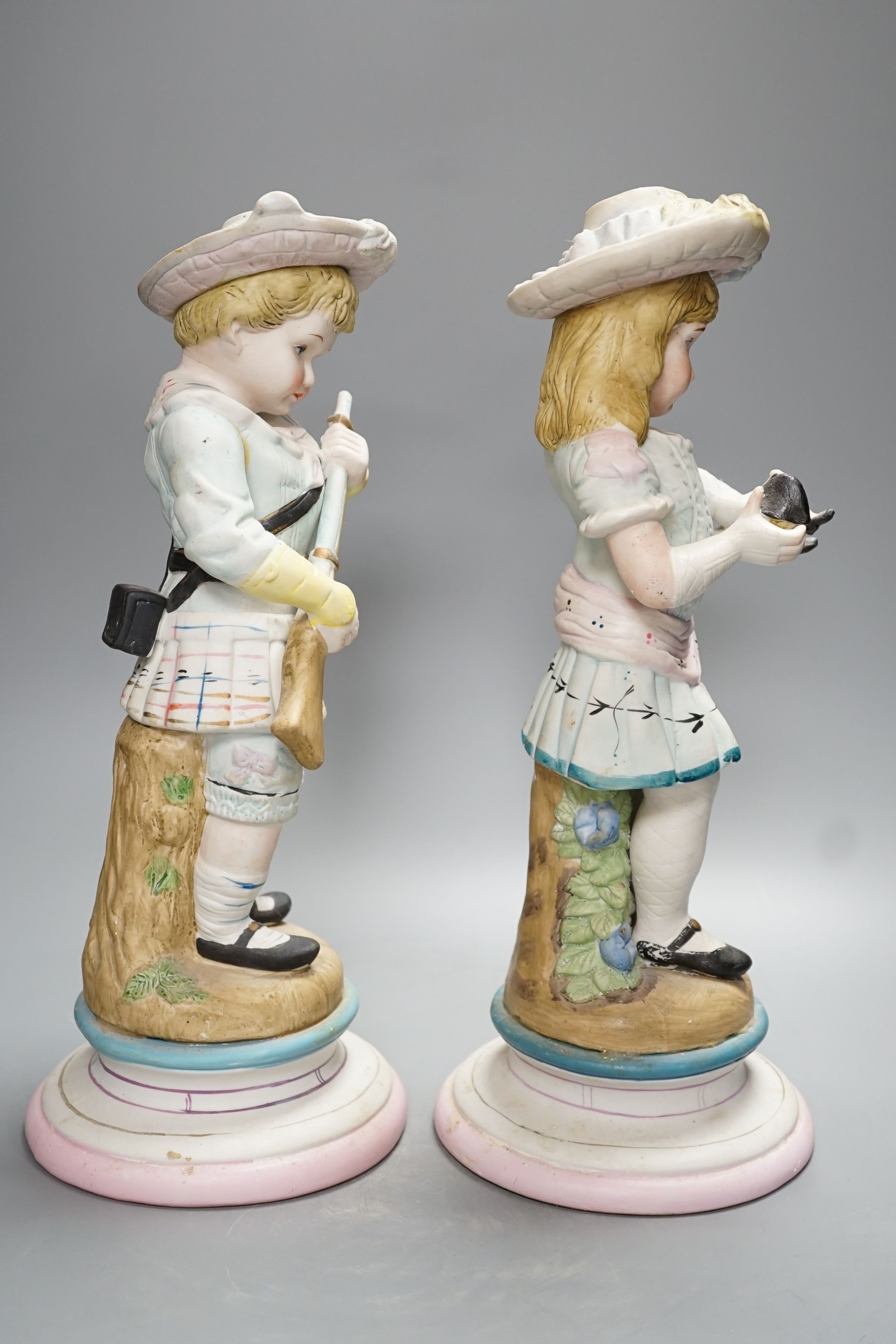 A pair of Continental coloured bisque figures of children - 39cm high